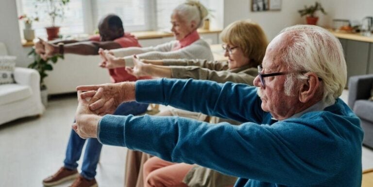 Elderly Group Doing Seated Chair Exercises at Assisted Living Facility