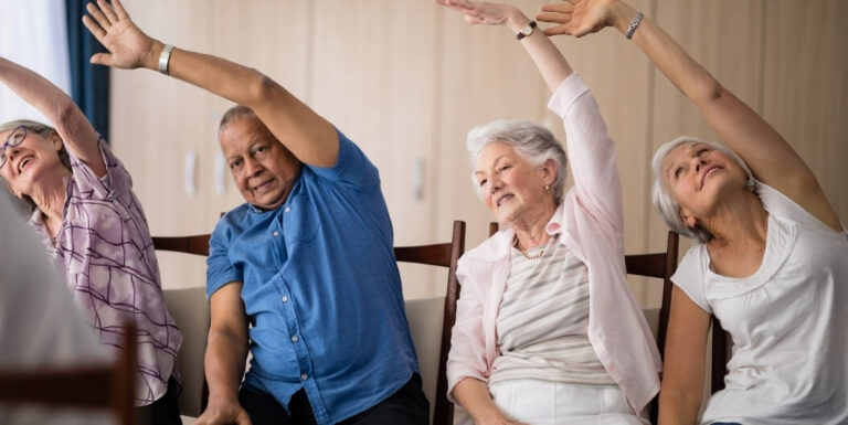 Elderly Residents Doing Chair Yoga Exercises at Assisted Living Facility